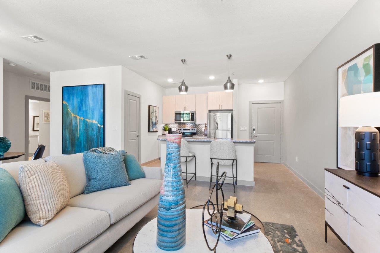 a living room and kitchen with a couch and a table